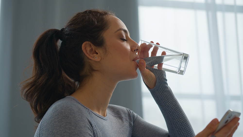 Woman drinking water while doing her weight loss programs