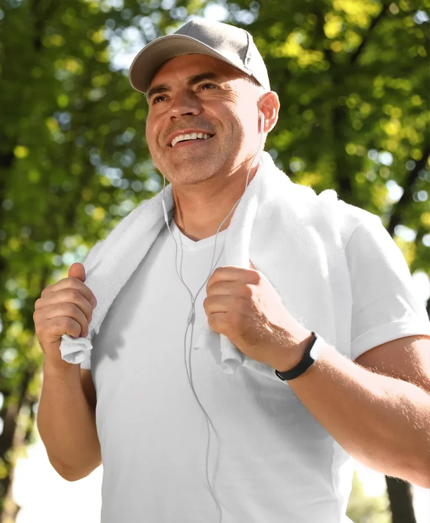 Peptide Therapy | Middle aged man outside smiling with a towel wrapped around his neck