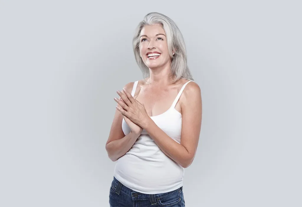 Peptide Therapy | Middle aged woman smiliing and looking up with hands clasped