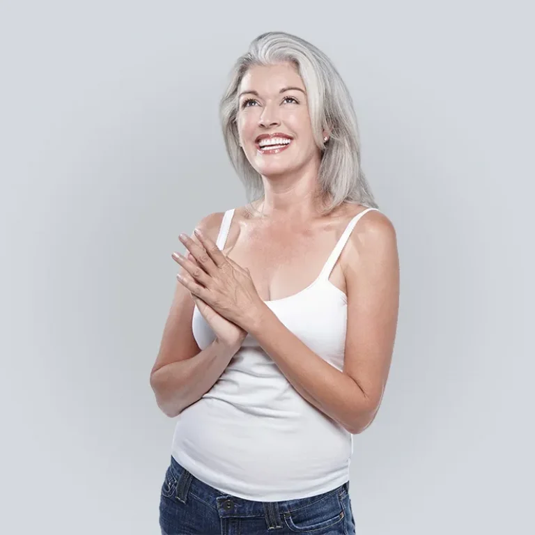 Peptide Therapy | Middle aged woman smiliing and looking up with hands clasped